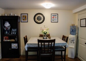 Dining area has bar height table and 4 cushioned chairs. Shelf has games & craft