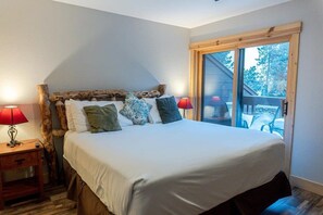 The home has two bedrooms, each with a king-size bed, twin over twin bunk beds, and an en suite bathroom with shower tubs making them ideal for young families and larger groups. This bedroom also features a patio with a lovely view of the mountains.