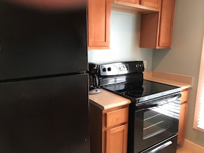 Full kitchen with new, full size fridge, oven and cooktop