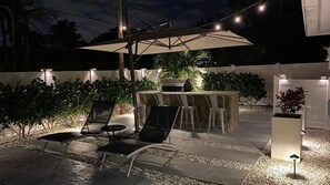 Elegantly lit and landscaped backyard lounge.