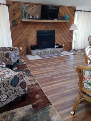 PORTION OF THE GREAT AREA WITH THE NEW FLOOR AN THE FIREPLACE ON THE BACKGROUND