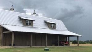 Side porch with view to back pasture and enjoy an outdoor shower in nature. 