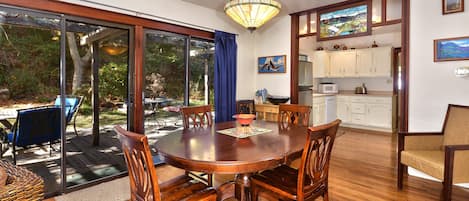 Dining room with view to back deck and kitchen on right