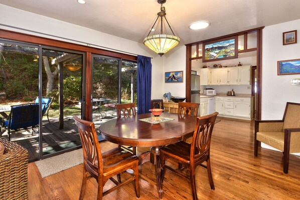 Dining room with view to back deck and kitchen on right