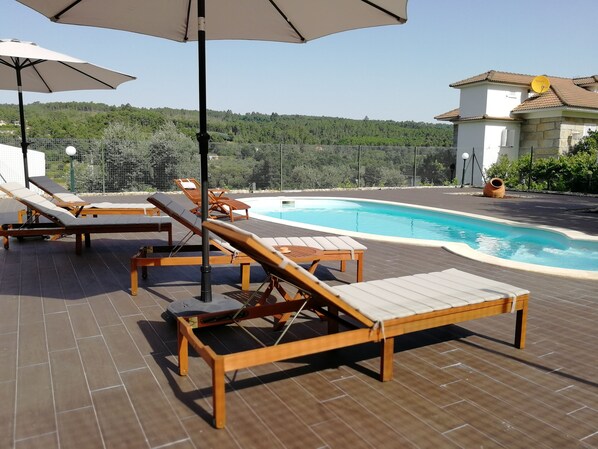 Piscina vedada, sazonal com espreguiçadeiras e chapéus de Sol