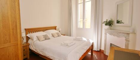 Main bedroom with king-sized bed, white bed linen and fluffy towels