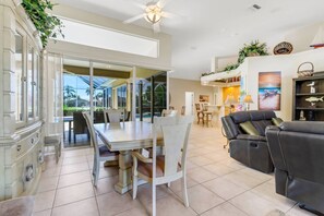 The formal dining area is beautifully situated with a view of the lanai and canal through the fully opening 90 degree glass doors.