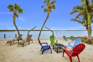 Your own private beach next to the water with lounge chairs and a fire pit.