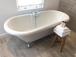 The indulgent roll-top bath in the spacious bathroom