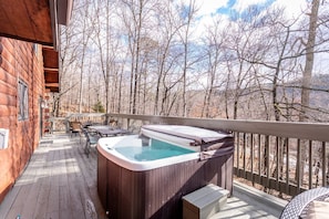 Expansive deck with hot tub, outdoor seating, and firetable