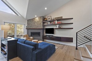 Open living space with gas fireplace and open to deck