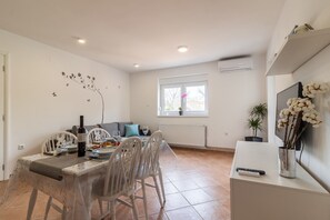 Flat TV provided in the living room, with the entrance on the terrace and shared garden with grill and children's playground