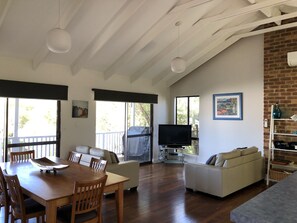 Open plan living and kitchen, with raking ceilings.