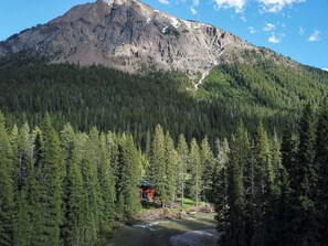 House nestled between Mount Republic and Soda Butte Creek