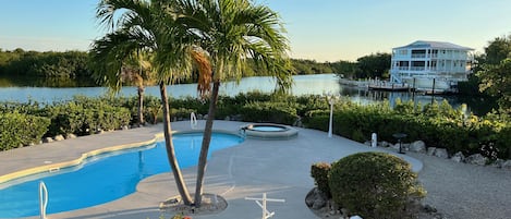 Backyard, pool & hot tub. Table w/ chairs as well as several lounge chairs. 