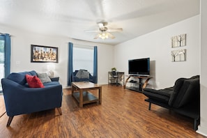 Relax and recharge in this living room complete with a laptop workstation and a large flat screen TV preloaded with all four major streaming channels.