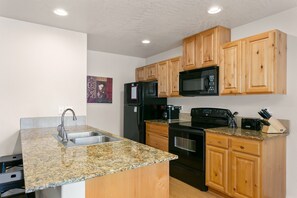 Granite counters, natural wood cabinets and upgraded appliances in this spacious and fully stocked kitchen.