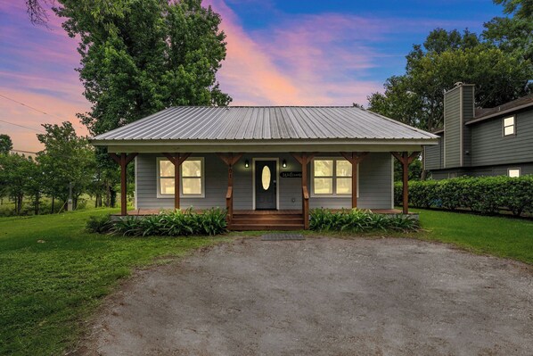 "Beautiful & spacious cottage in quiet area. Easily fit a family of 7, very peaceful by the river. Fantastic stay, we loved it!" Front porch dusk
