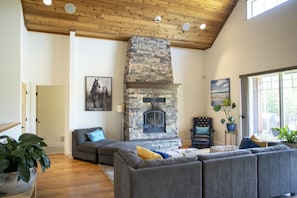 Living Room; wood floors and cedar clad peaked ceilings with large fireplace