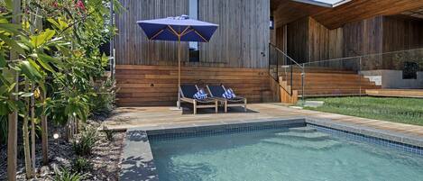 shimmering pool and an inviting wooden deck