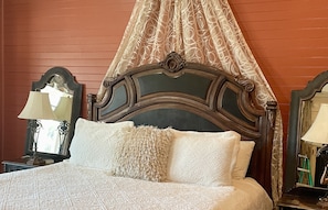Luxurious king size bed with fine linens takes center stage.