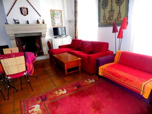 The two sofas (one a sofabed), with fireplace and television in the background.