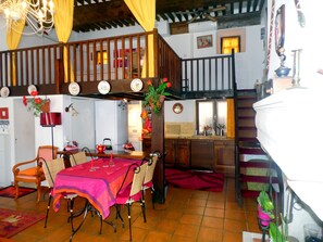 View of the dining table and the kitchen, with the sleeping loft above.