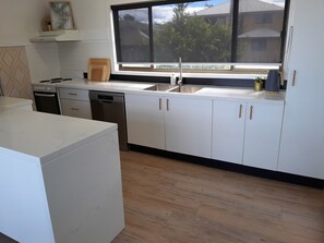 Full kitchen with stone benchtops, dishwasher,oven and nespresso coffee machine