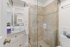 Bathroom with walk in shower, vanity and toilet. 