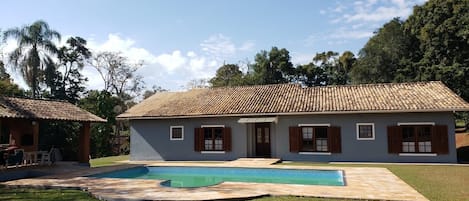 Vista externa com piscina e churrasqueira à esquerda