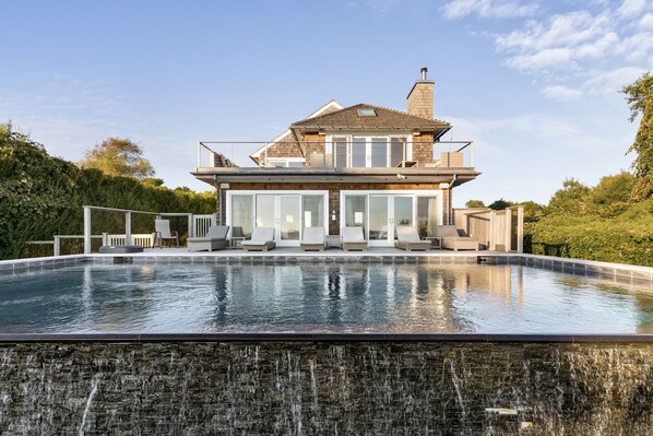 Amazing infinity waterfall pool with water views.