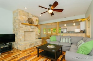 Open floorplan living area, with wood burning fireplace. 