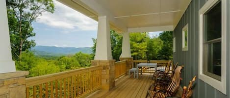 Rocking chairs on a huge covered proch with view and dining.