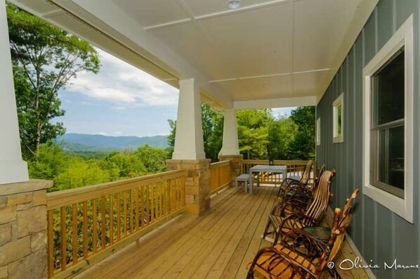 Rocking chairs on a huge covered proch with view and dining.