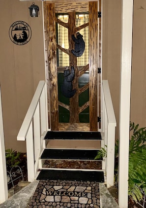 Hand-carved bear screen door entry, only 2 half steps into cabin, all on 1 floor