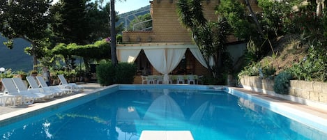 La zona pranzo esterna vista dalla piscina