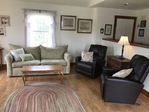 The living room has a cathedral ceiling with a pull out sofa and 2 recliners.