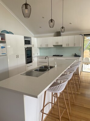 Kitchen with stone bench tops, 2 full sized fridges, dishwasher and microwave