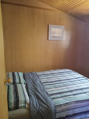 Queen bed bedroom with a night table and a dresser.