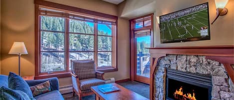 Living room with queen sofabed, door to private deck and LED HDTV.