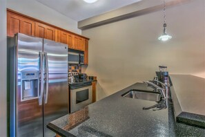 Kitchen with granite counters, refrigerator, oven, microwave and dishwasher.