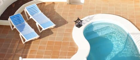 Terraza con piscina, privada con cuatro hamacas y salida directa al mar.