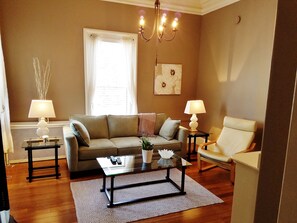 Living room with 12 foot ceiling. Sofa opens to comfortable queen size bed