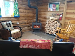 Very cozy living room space, complete with lots of firewood and comfy chairs