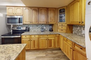 Fully Equipped Kitchen with Stainless Appliances, New Granite Countertops, and a wide selection of Cooking Equipment.