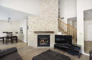 Gas burning fireplace with stone surround and 65" HDTV with surround sound