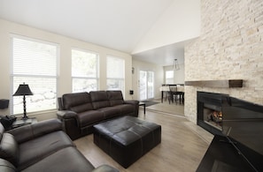 Living room with gorgeous gas fireplace with stone surround.