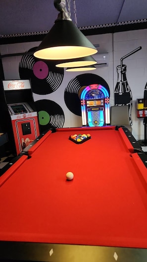 Retro games room with pool table, juke box, arcade game, and shuffle board