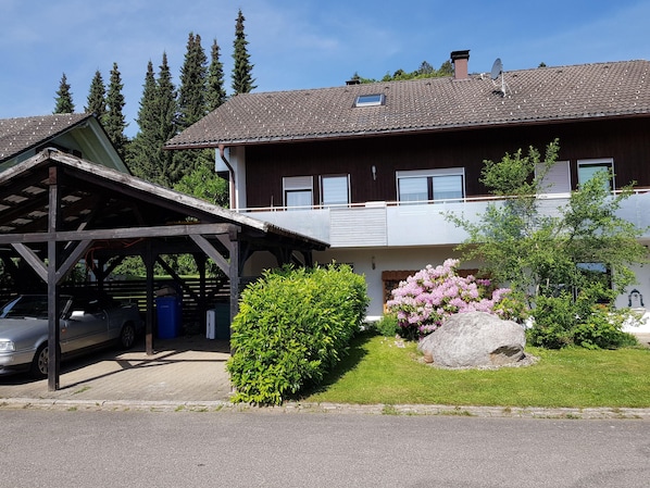 Vorderansicht mit Parkmöglichkeiten im Carport oder Stellplatz direkt am Haus.