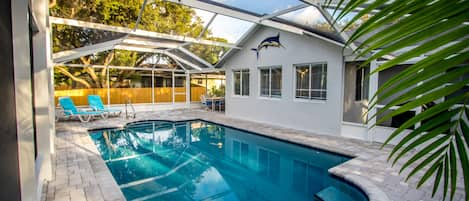 Outdoor living with screened heated pool and adjacent BBQ porch